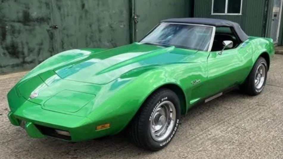 A green Corvette convertible classic car which is parked.