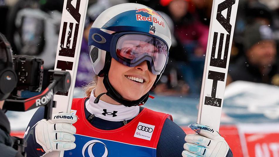 Lindsey Vonn smiles while holding her skis during the FIS Alpine Ski World Cup Women's Downhill in Zauchensee, Austria
