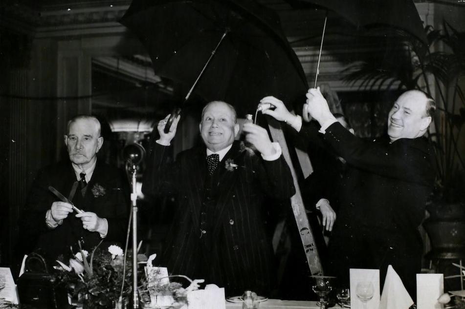 Mr Albert Marchi, Chairman of the club addressing the diners at the luncheon under open umbrellas, while fellow member sprinkles him with salt. Another member on the left has two knives crossed, London, England. (Photo by Hulton Archive/Getty Images) DEFYING FATE.
-Members of the "13 Club" are shown at
luncheon on February 13 at the Cafe Royal in London The chairman
(Mr Albert Minchin), who has just recovered from two broken legs, is
shown being christened with salt as he stands beneath an umbrella which
he has just opened indoors