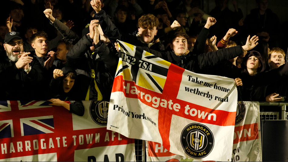 Harrogate Town fans celebrate after their team's win over League One Wrexham in the first round of the FA Cup