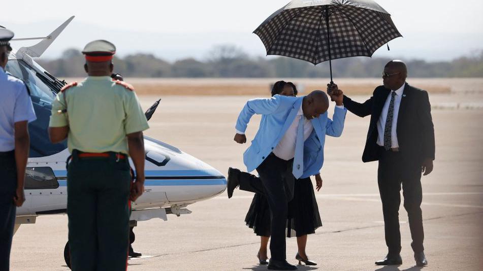 Botswana's president dances on the airport tarmac before greeting the  country's athletes on their way home