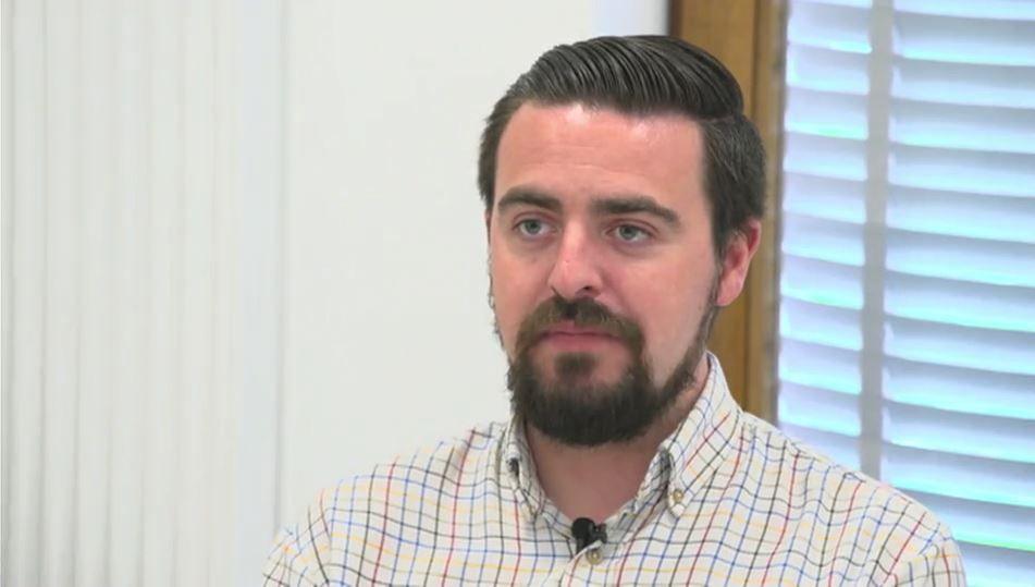 Councillor Sam Smith, sat in an office, looking to the left of the camera