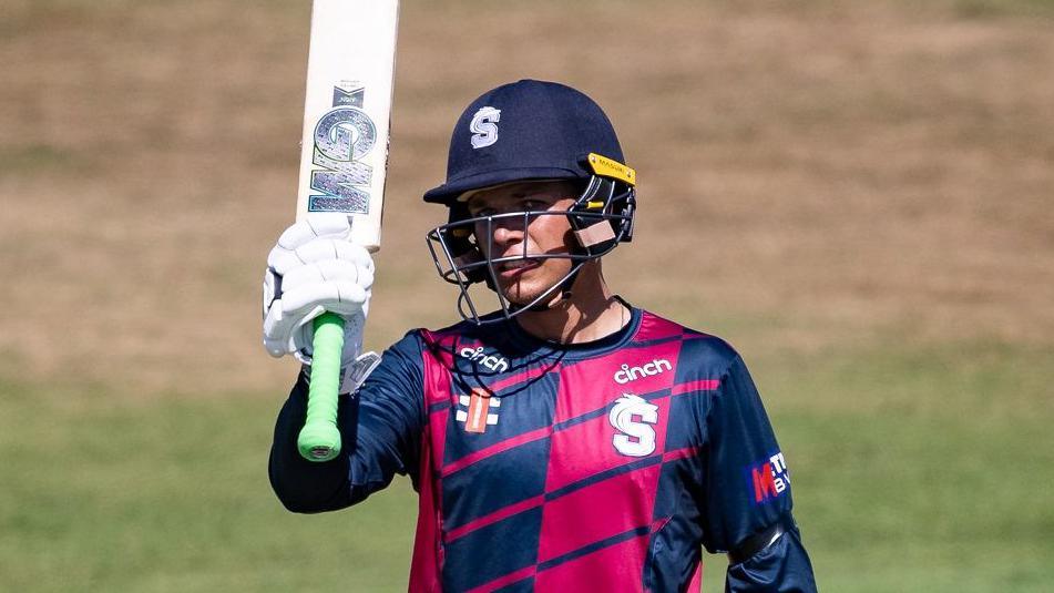 Stuart van der Merwe raises his bat after reaching his half-century against Sussex