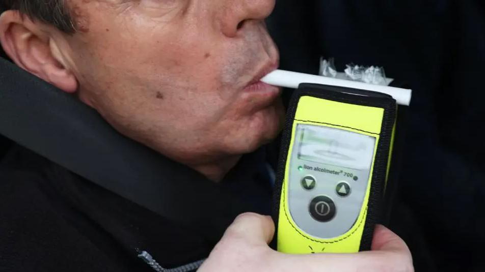 A man breathes into a breathalyser