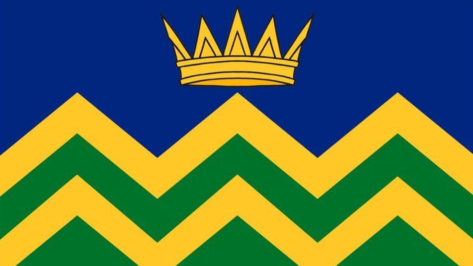Graphic of a flag design showing a gold crown on a blue background above a yellow and green zig-zag pattern.