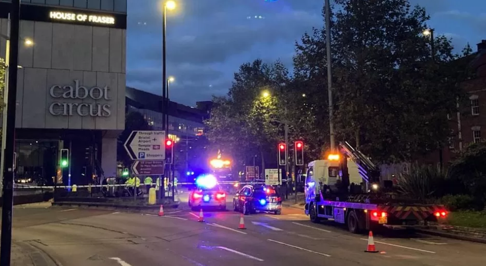 Emergency crews outside shopping centre at night.