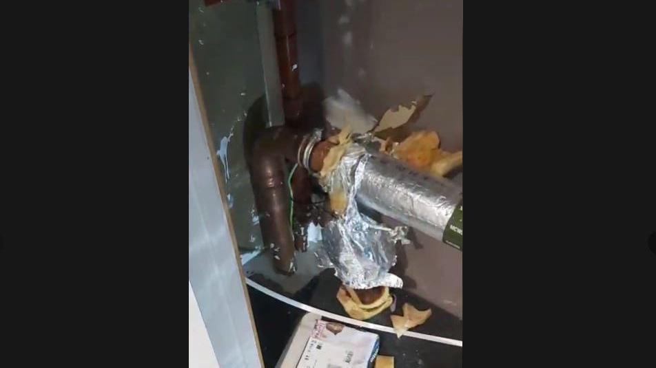 A broken pipe in a cupboard. 