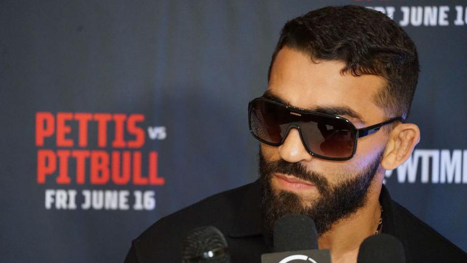 Patricio 'Pitbull' Freire, with sunglasses on, answers a question at a news conference