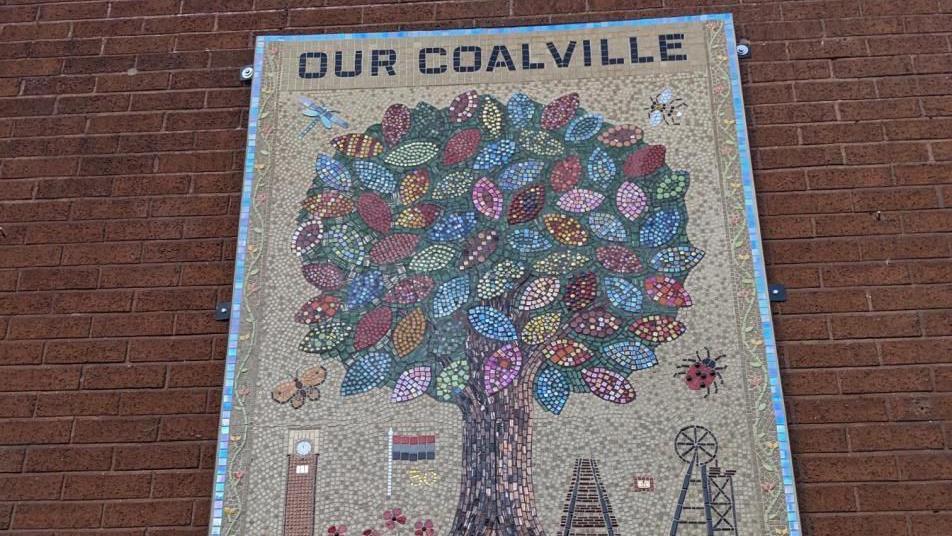 A large colorful mosaic of a tree with words that read "Our Coalville"