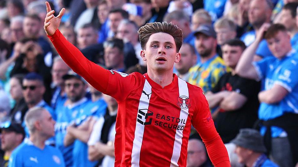 Ollie O'Neill celebrates with his hand in the air after scoring for Leyton Orient against Stockport County