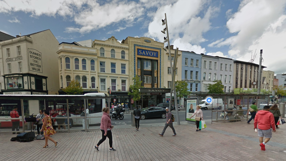 A Google Maps screen grab of St Patrick's St in Cork city centre.   There are shoppers walking along the street, parked cars and the Savoy cinema is in the background.