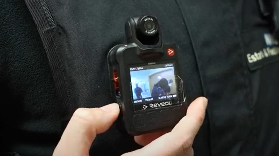 A close-up of a camera stuck on a person's front playing back footage