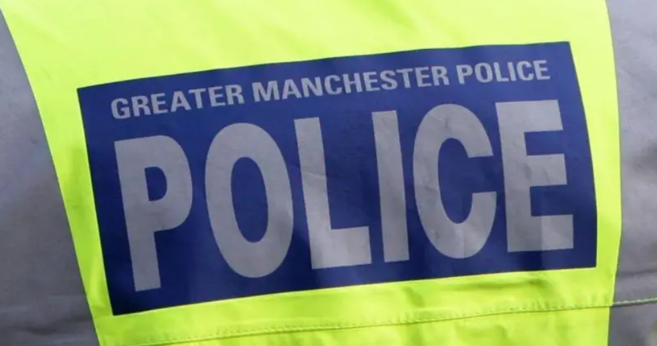 An image of the back of a police man's hi-vis jacket, which bears the name Greater Manchester Police