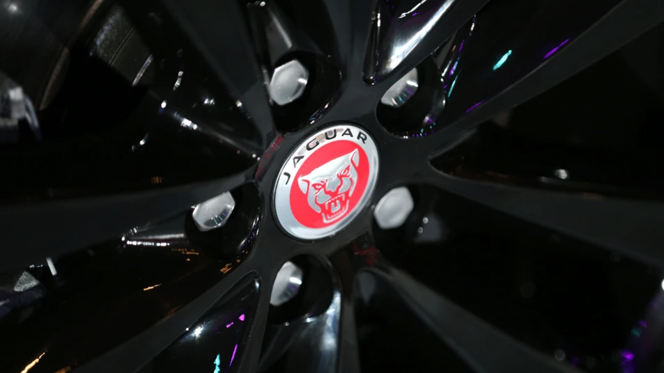 A close of of a Jaguar car's wheel. It has a red logo of in the centre with the word Jaguar above it.