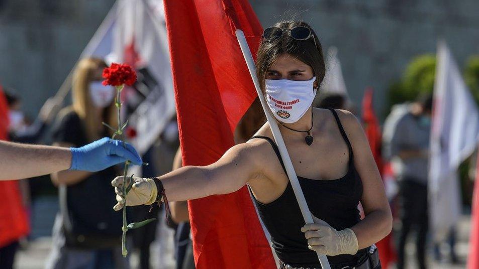 A woman hands out red carnations