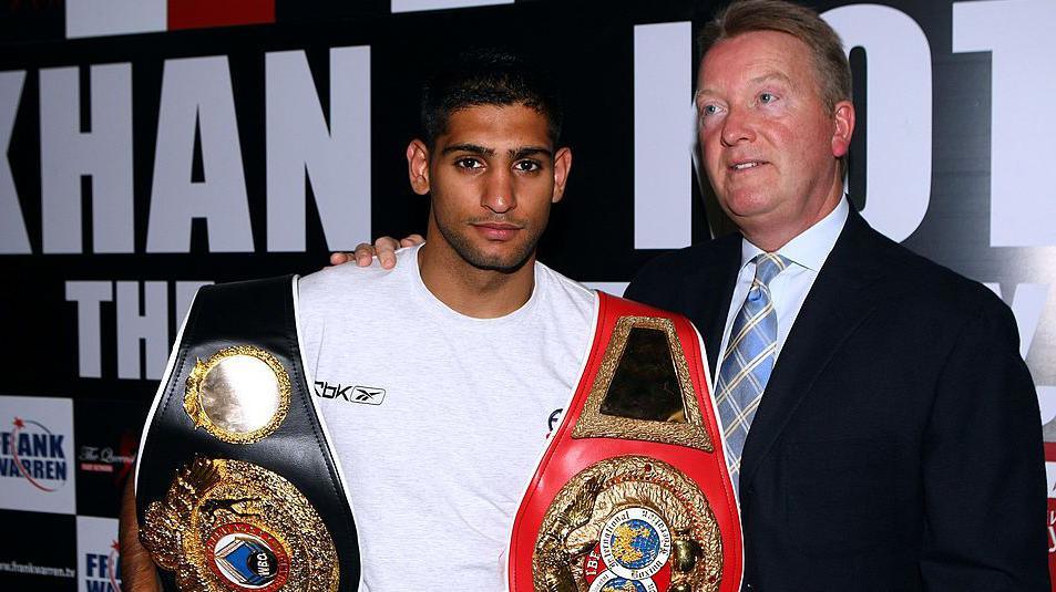 Frank Warren puts his arm around Amir Khan, who is holding his world titles