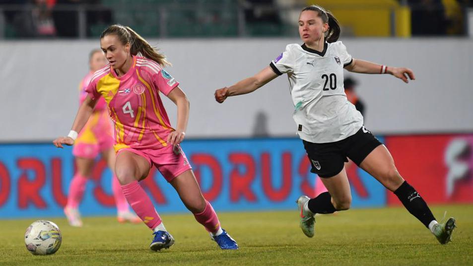 Austria's Lilli Purtscheller dribbling the ball with a scotland player trying to tackle