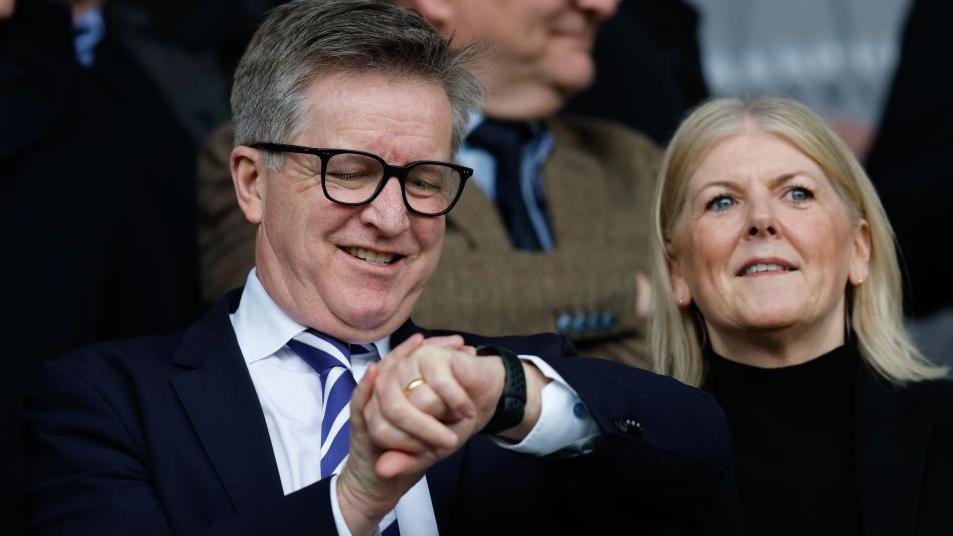 Andrew Cullen checks his watch in the stands during a Portsmouth game