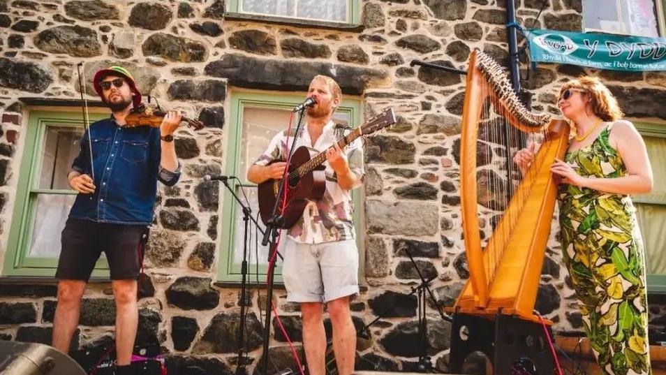 Perfformiad ar y stryd yn Nolgellau gan Gwilym Bowen Rhys ac offerynwyr