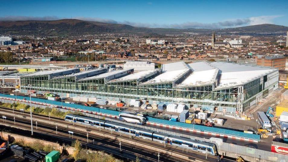 Belfast's Grand Central Station under construction with buses and trains in the foreground