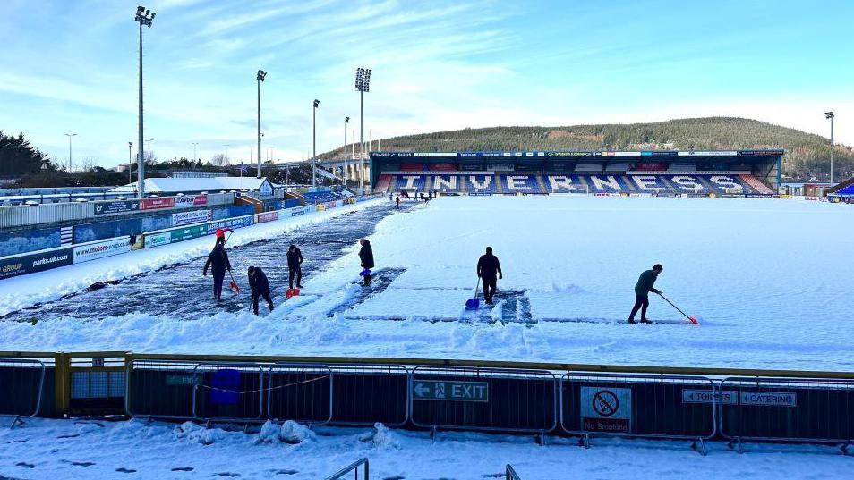 Clearing snow from ICTFC pitch on Friday