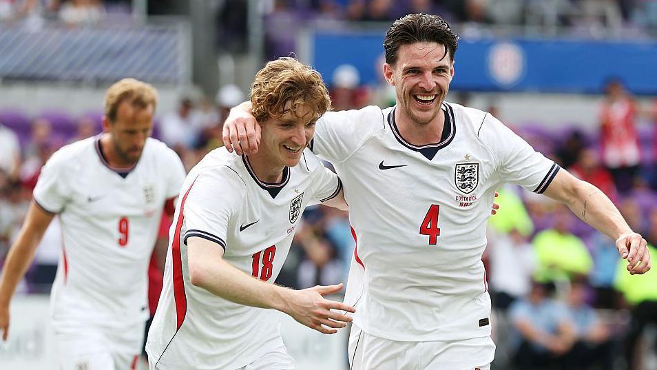 Declan Rice celebrates with Anthony Gordon after putting England ahead in the pre-World Cup friendly against Costa Rica in Orlando. Both are in white kit with red and dark blue trim
