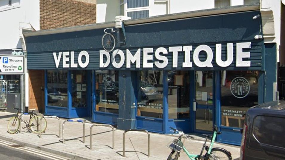 Google Street View of Velo Domestique cycle cafe with a blue frontage and a white sign