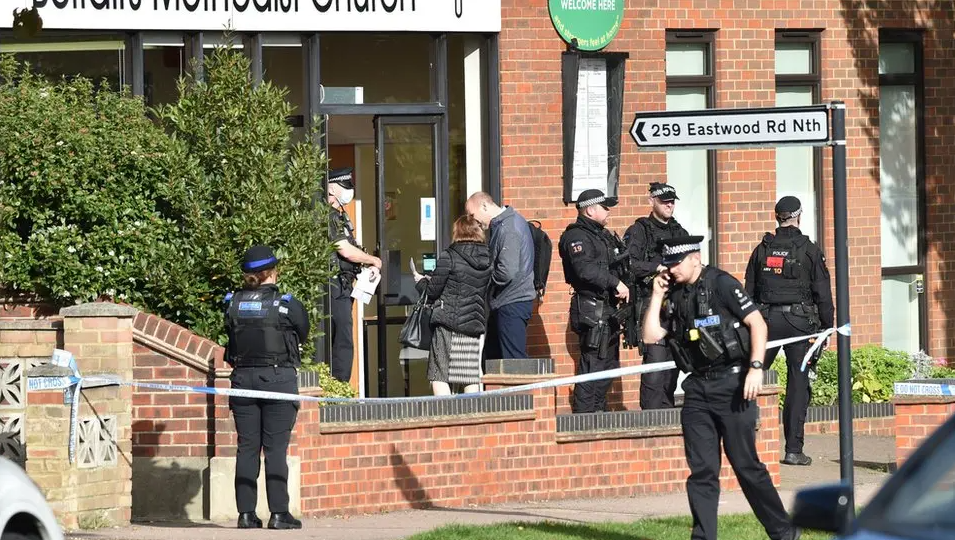 Armed police and members of the public outside a brick building in which MP Sir David Amess was killed in 2021