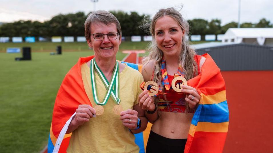 Two women holding medals