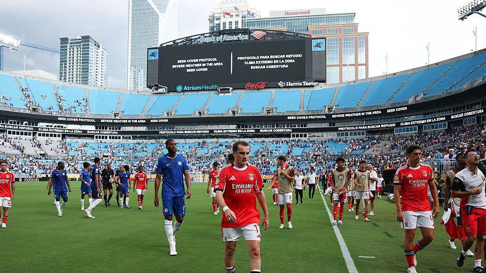 Chelsea and Benfica players walking off the pitch after severe weather in the United States