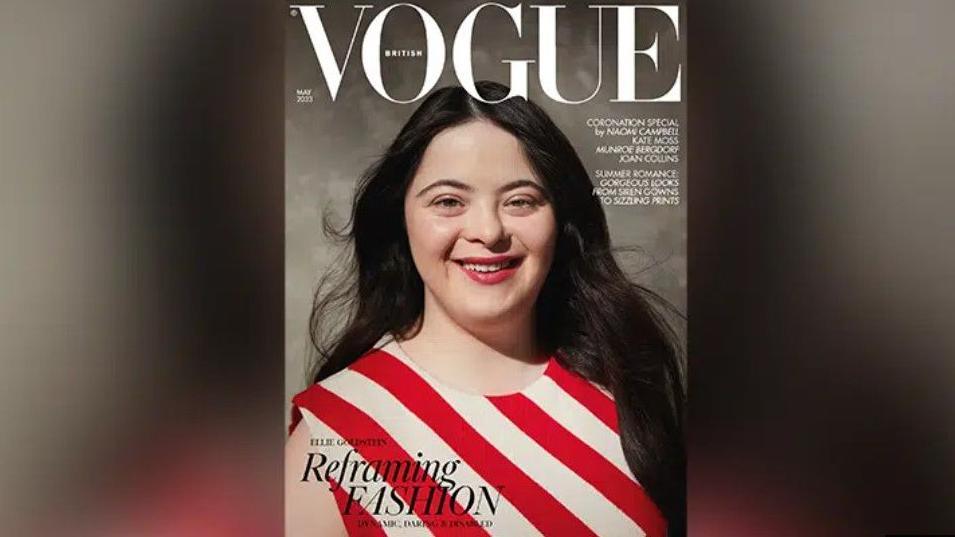 Ellie on the front of Vogue magazine. She is wearing a red and white striped top. She has long brown hair and is smiling.