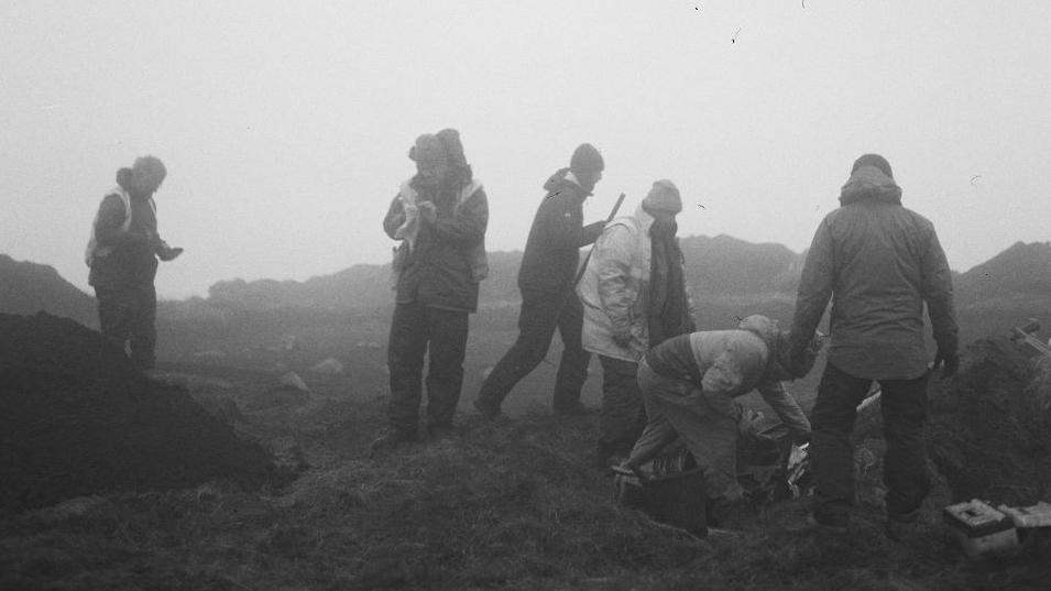 Six archaeologists working on a misty day