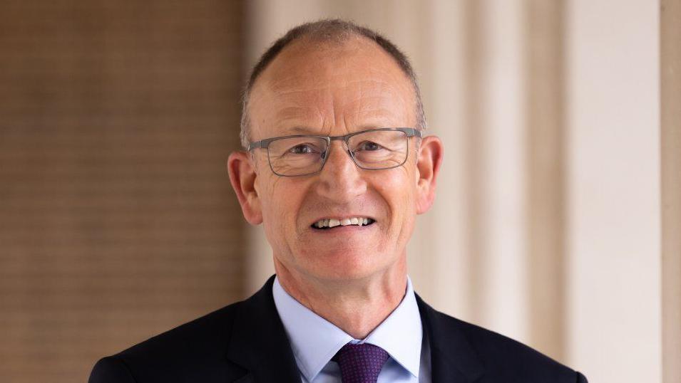 A picture of Hertfordshire County Council leader Richard Roberts wearing a black jacket with a purple tie.