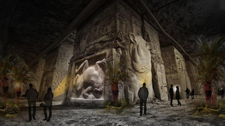 A CGI image of how the attraction would look inside the cavernous mine. The vast stone walls are carved with relief sculptures of animals including a frog and a rhino. Silhouettes of visitors are dwarfed by the exhibits.