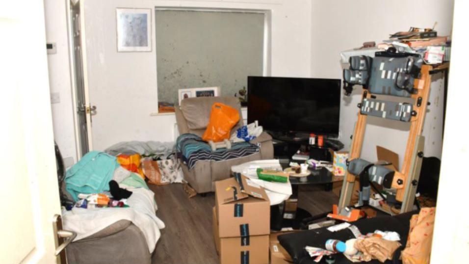 A picture of a cluttered living room taken as police evidence