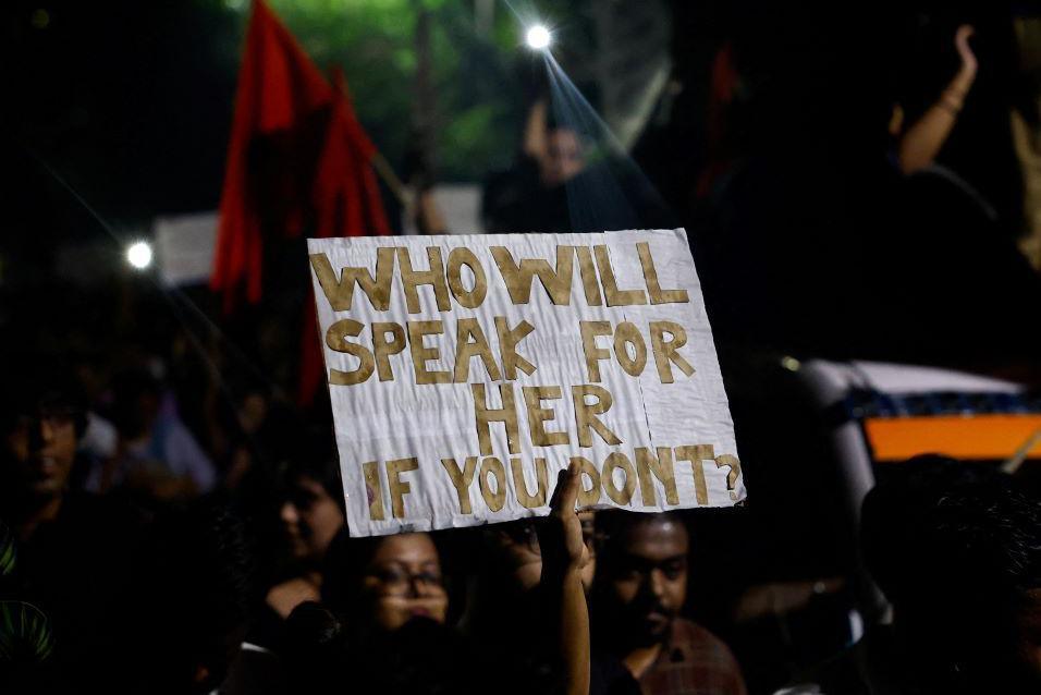 A woman holds a placard as she attends a candlelight vigil held outside Jadavpur University campus, condemning the rape and murder of a trainee medic at a government-run hospital in Kolkata, Ind