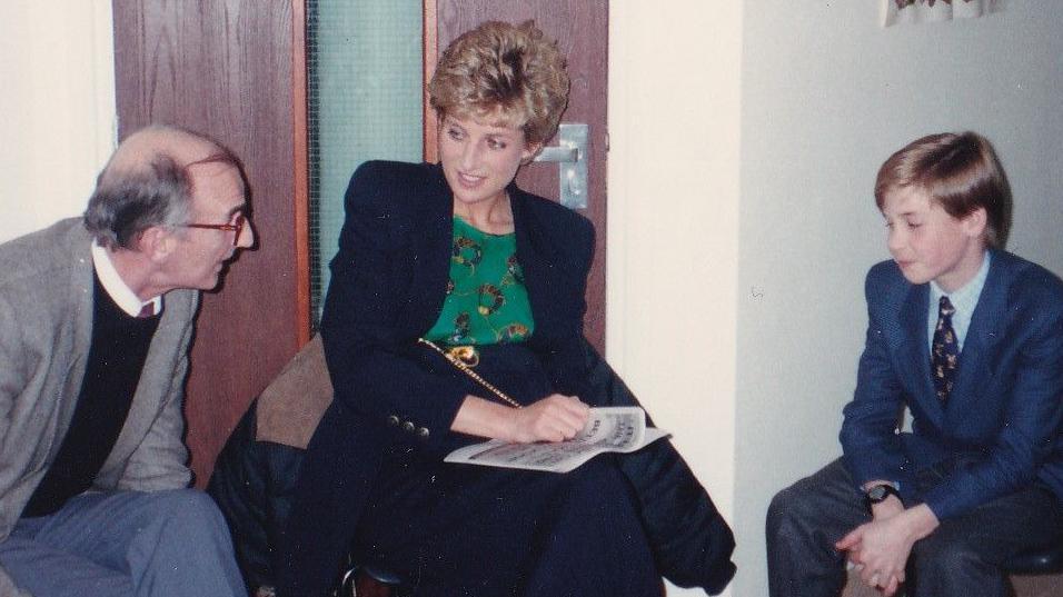 The late Princess Diana in a navy jacket and green blouse, sitting between a member of staff, to her left, and her son, 11-year-old Prince William, in a suit and tie, at The Passage in Westminster, London.