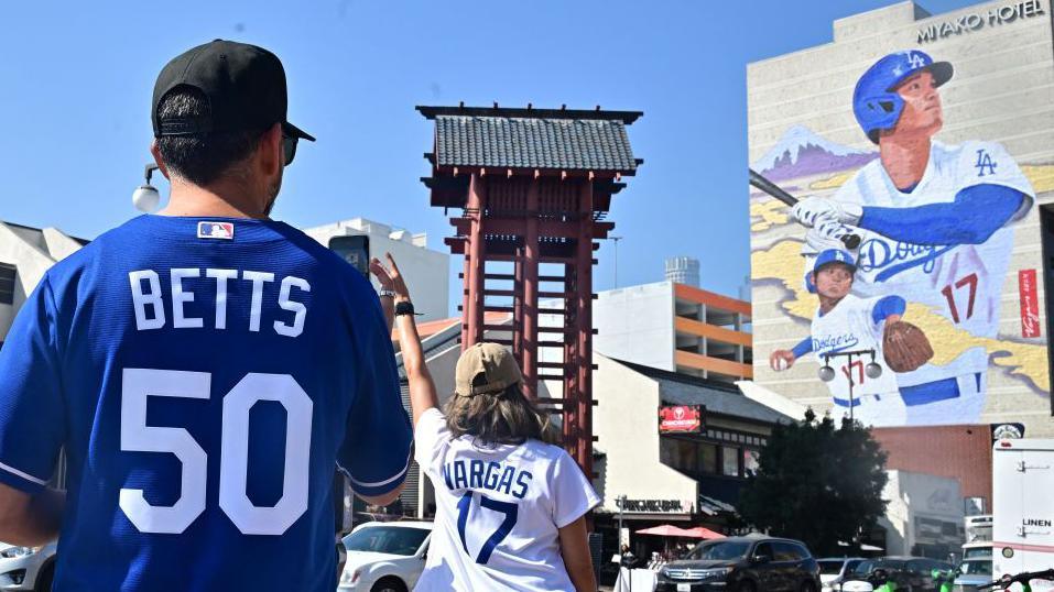 Tourists pose for a photo in front of a massive mural of Shohei Ohtani in the Los Angeles neighbourhood of Little Tokyo 