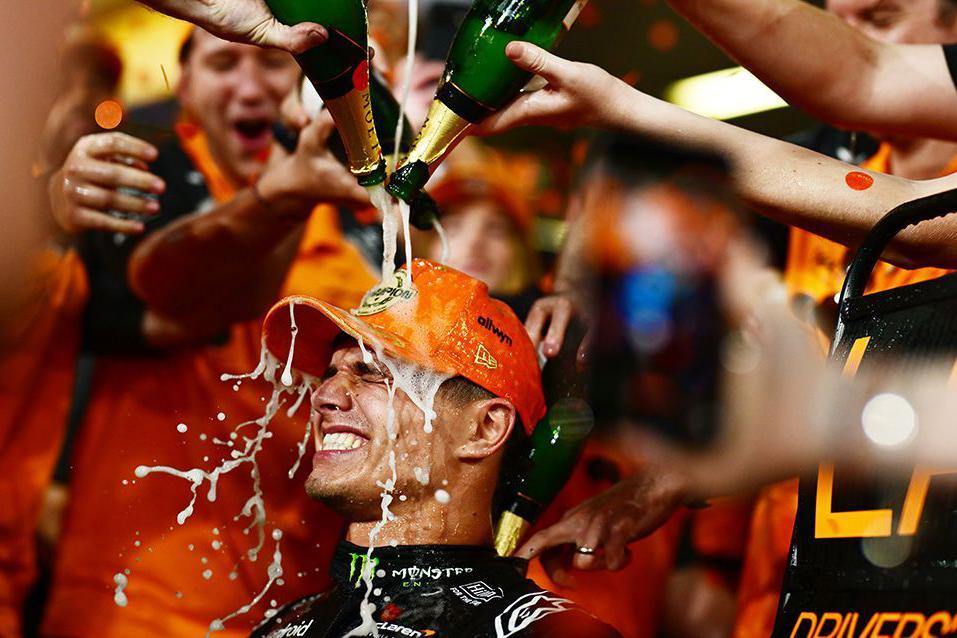 Britain's new Formula 1 champion Lando Norris has champagne poured over him as he celebrates securing his first championship at the Abu Dhabi Grand Prix.