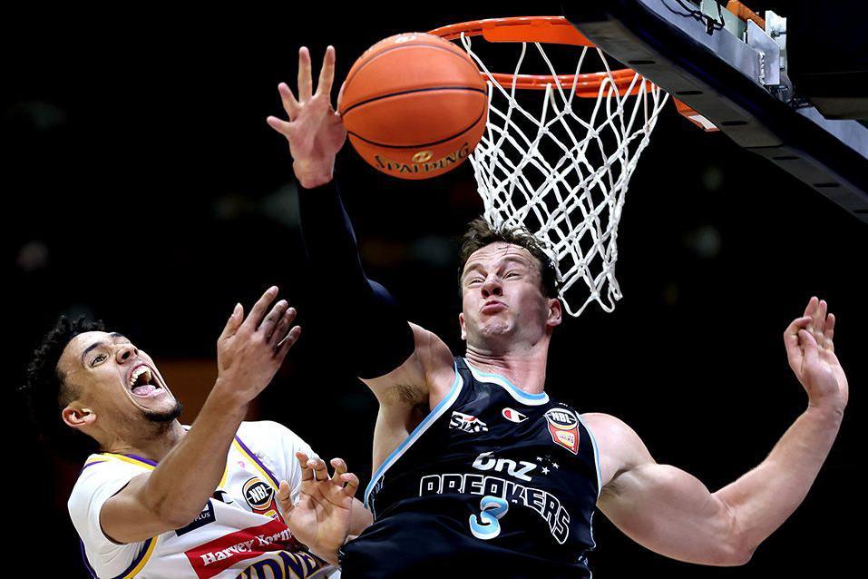Jaylin Galloway shoots for the basketball net from close range while under pressure from Sam Mennenga as both players show strained facial expressions