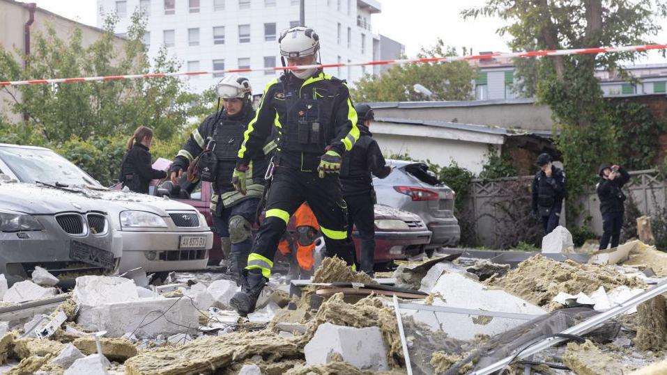 Rescue workers respond at the site on a Russian airstrike of a multi-storey residential building with a UMPB D-30 glide bomb on May 14, 2024 in Kharkiv, Ukraine