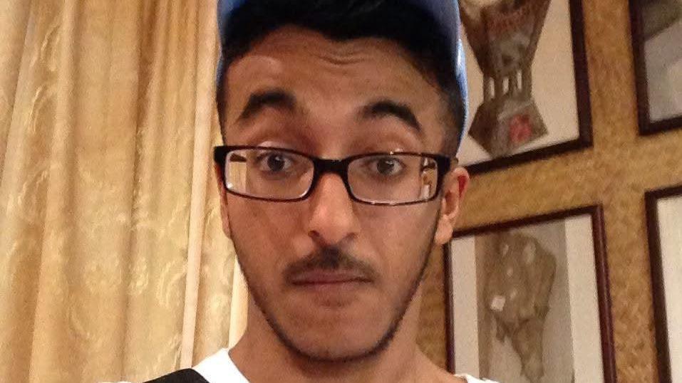 Mazin Kaladi looks at the camera. He has dark facial hair and is wearing a blue baseball cap and dark glasses.
