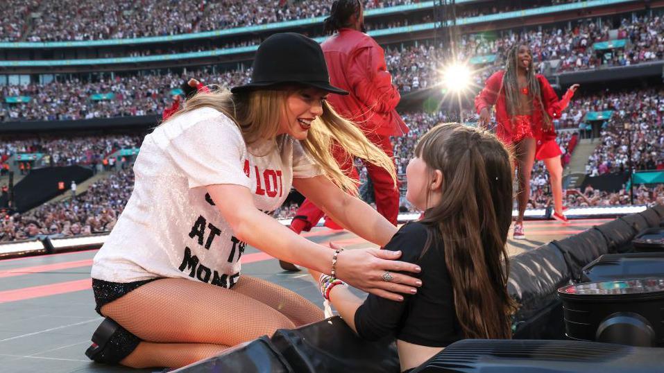 Taylor Swift hugs a young fan during her Era's tour.