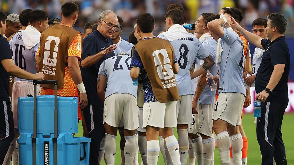 Uruguay's players listen to instructions from Marcelo Biesla during a hydration break 