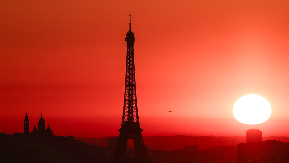 The sun rises by the Eiffel Tower in Paris as the city is on red alert for high temperatures, with the top of the Eiffel Tower shut