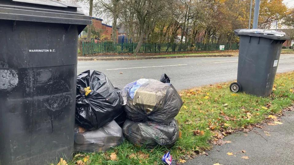 Rubbish bags next to a bin in Warrington