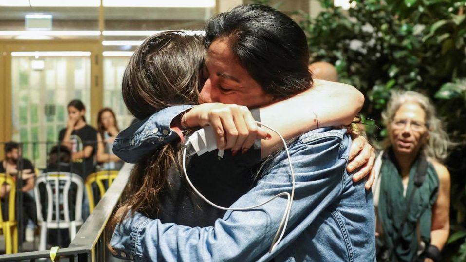 Einav Zangauker, the mother of hostage Matan Zangauker, is hugged by another woman after Trump's announcement