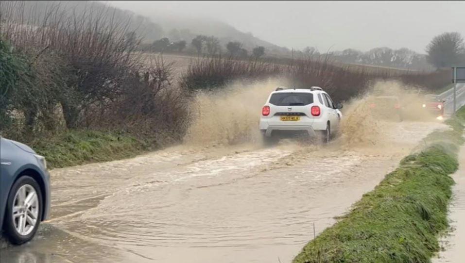 Cars driving along flooded road at Plumpton 