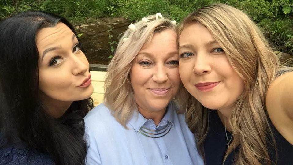 A selfie of three women. The woman on the left has long dark hair, the woman in the middle short blond hair and the woman on the right has shoulder-length blond hair