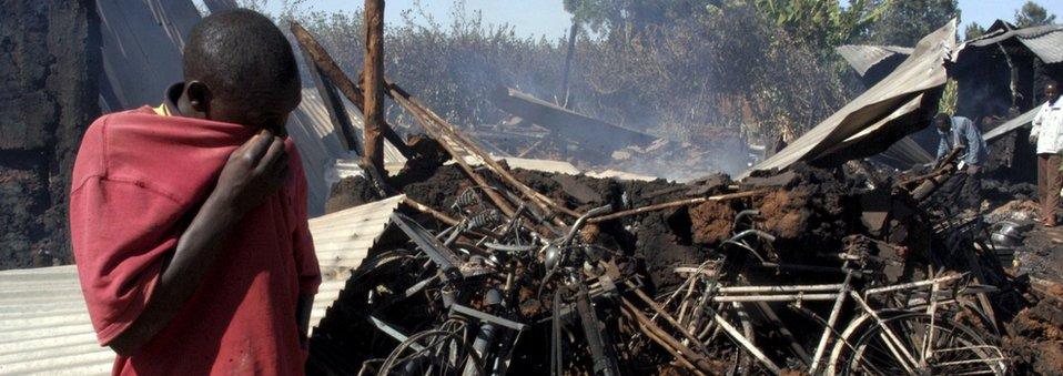 A man wipes his face in front of a church where some 30 people were burned alive in Eldoret in this January 1, 2008 file photo